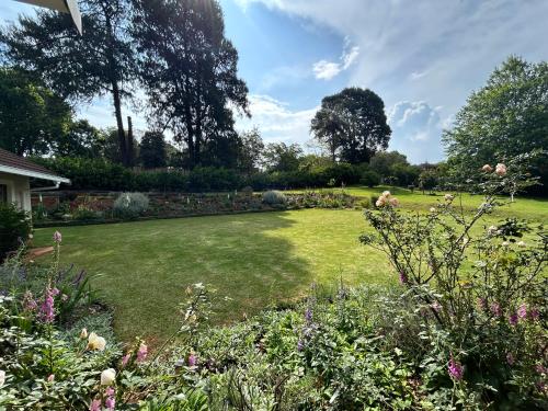 a garden with a large lawn with flowers at Cedara Way Hilton in Hilton