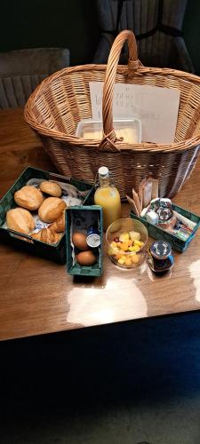 a basket of bread and eggs and a basket of orange juice at B&B De Blauwe Melkbus in Harskamp