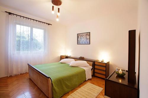 um quarto com uma cama e uma janela em Ana Apartment em Rabac