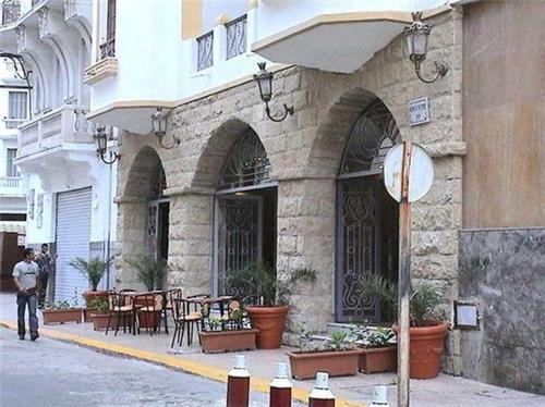 un bâtiment avec une table et des chaises devant lui dans l'établissement Hôtel Volubilis, à Casablanca