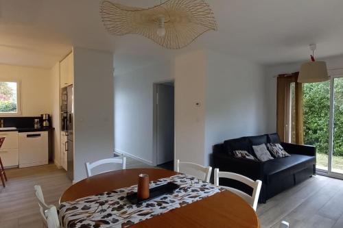 un salon avec une table et un canapé dans l'établissement Villa d'Orée, Bordeaux Saint-Aubin-de-Médoc, à Saint-Aubin-de-Médoc