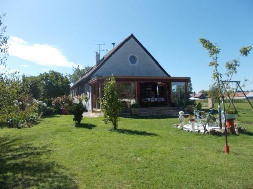 a house in a yard with a grass field at Chambres d'hôtes Les Quatre Vents in Ruca