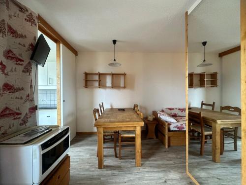 - une cuisine et une salle à manger avec une table et un four micro-ondes dans l'établissement Studio divisible rénové, pied des pistes, balcon, 4 pers., La Plagne - FR-1-181-1104, à Plagne Bellecôte