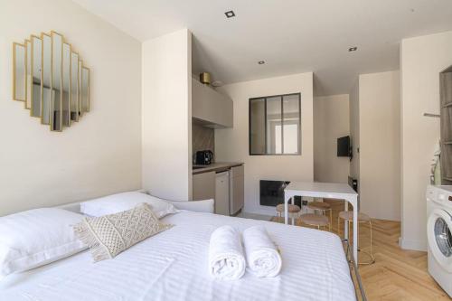 a white bed in a room with a washing machine at Studio with sleeping area for 4, Saint-Didier in Saint-Didier-au-Mont-dʼOr