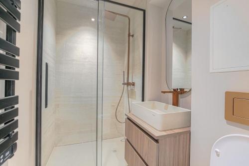 a bathroom with a glass shower and a sink at Studio with sleeping area for 4, Saint-Didier in Saint-Didier-au-Mont-dʼOr