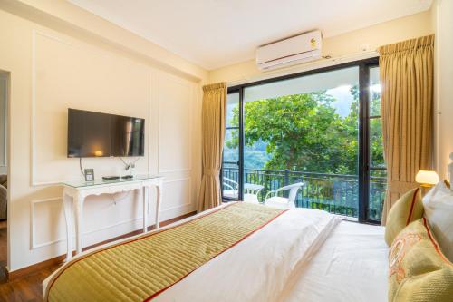 a bedroom with a bed and a balcony with a tv at Marten's Wilderness Retreat in Lansdowne