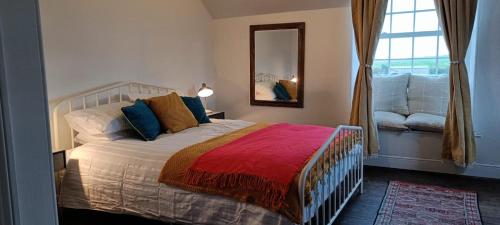 a bedroom with a bed with a mirror and a window at The Studio Trewarveneth Manor Farm TR185NF in Newlyn
