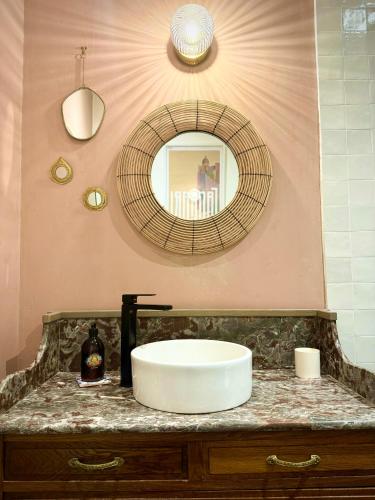 une salle de bain avec un lavabo et un miroir sur un comptoir dans l'établissement L'abreuvoir - Appartement Hypercentre Metz, à Metz