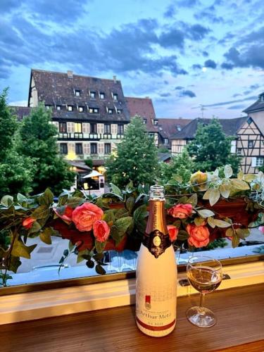 - une bouteille de vin assise sur une table à côté d'une fenêtre dans l'établissement Once upon a Time, luxury appart, 8 guests, 3BR, à Colmar