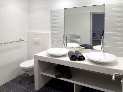 une salle de bain avec deux lavabos et un WC et un miroir dans l'établissement Villa Palombaggia, à Porto-Vecchio