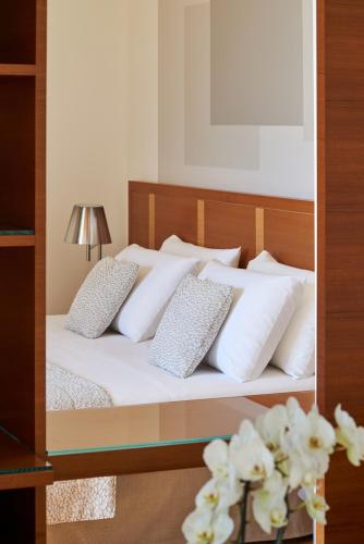 a bedroom with a bed with white pillows at Hotel Belvedere in Bellagio