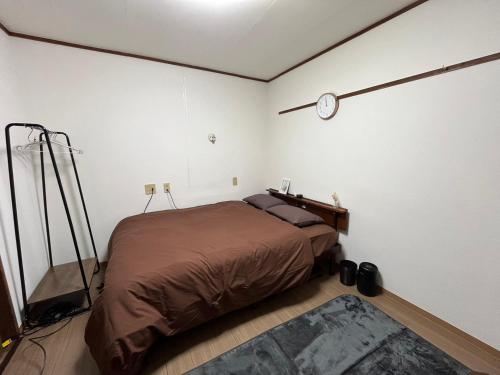 太宰府市にあるGuest House Happy Highness DAZAIFUのベッドルーム1室(ベッド1台、壁掛け時計付)