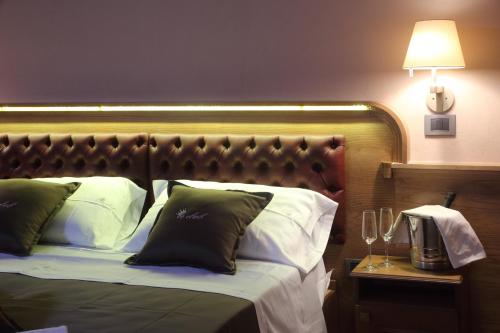 a bed with a headboard and a table with a lamp at Le Club Boutique Hotel in Lecce