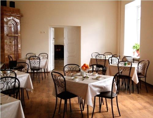 une salle à manger avec des tables, des chaises et un tissu de table blanc dans l'établissement Lesogorskaya estate RUUSYAVI, à Lesogorskiy