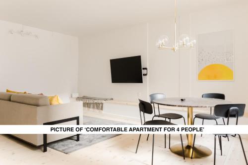 a living room with a table and chairs and a tv at Central City Apartment on Best Location by Round Tower in Copenhagen