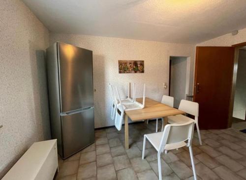 a kitchen with a table and a stainless steel refrigerator at LOW BUDGET Wohnungen für Monteure in Hohenstadt Smart TV, Wifi, Parking in Hohenstadt