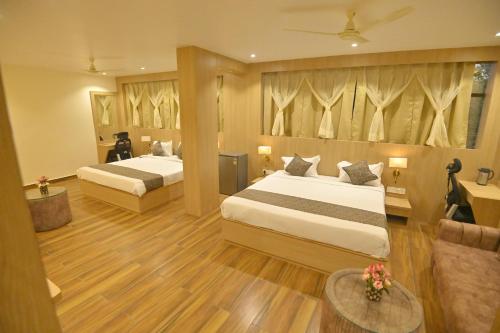 a hotel room with two beds and a couch at Hotel JK palace in Allahābād