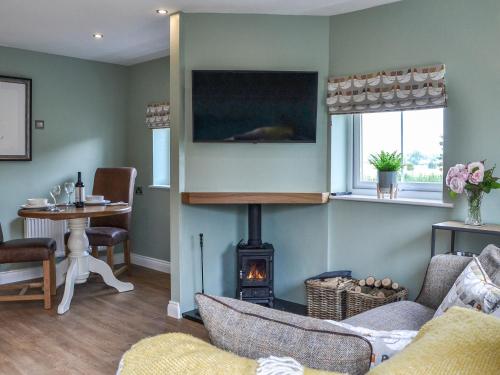a living room with a fireplace and a tv at The Hen House - Uk38436 in Kilham
