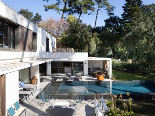 une maison avec une piscine et une terrasse dans l'établissement Villa d'exception avec piscine chauffée, proche plages et commodités - FR-1-791-22, à Soorts-Hossegor