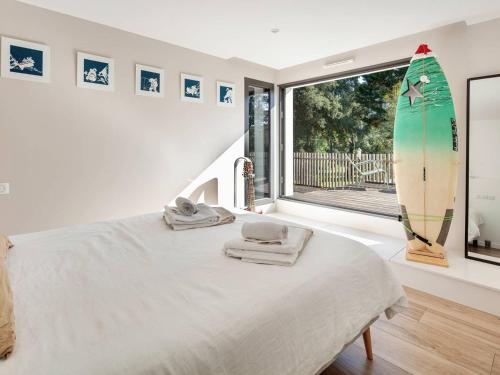 - une chambre avec un lit et une planche de surf sur le mur dans l'établissement Villa d'exception avec piscine chauffée, proche plages et commodités - FR-1-791-22, à Soorts-Hossegor