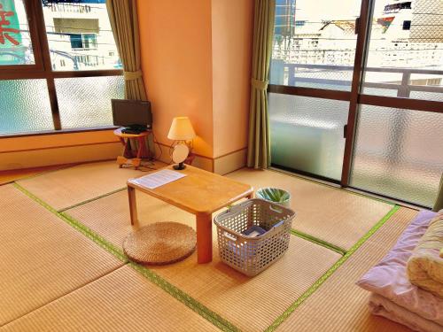 a living room with a table and a window at Hostel Hakuseiso in Naha