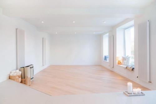an empty living room with white walls and wood floors at Spa Górka in Szklarska Poręba