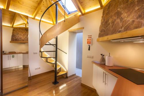 a spiral staircase in a room with a kitchen at Sao Thiago House Madeira in Funchal