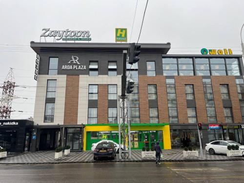 a building on a street with cars parked in front of it at Arda Plaza Hotel in Tashkent