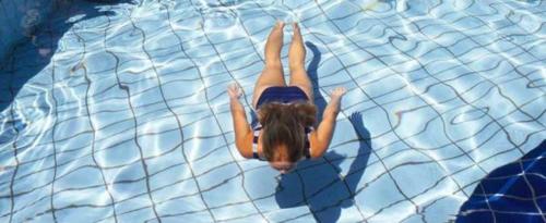 a woman is laying in the water in a pool at Sea Sun in Plomarion
