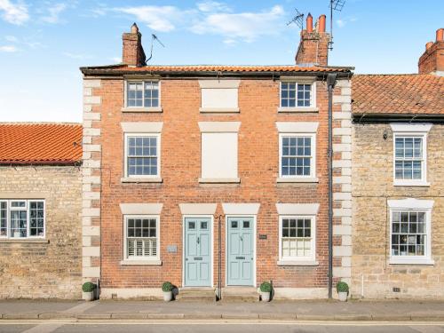 an old brick building with blue doors and windows at Ryburn House - Uk43518 in Thornton Dale