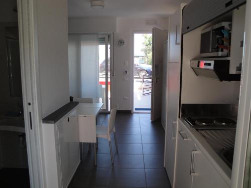a kitchen with white cabinets and a table and chairs at Residence La Nave in Senigallia