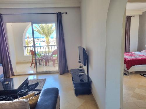 un salon avec un canapé et une télévision et un balcon dans l'établissement Houmet Souk Marina, à Djerba