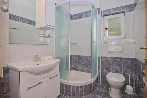 a bathroom with a sink and a toilet and a shower at Villa Malisko in Hvar