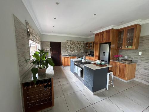 a large kitchen with wooden cabinets and a blue island at Cedara Way Hilton in Hilton