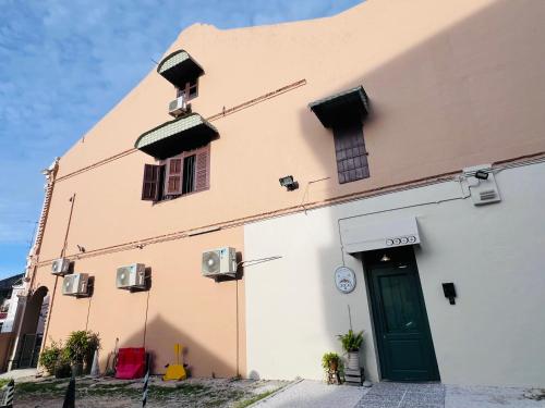 ein Gebäude mit einer grünen Tür und zwei Fenstern in der Unterkunft CHCH by LEJU in Malakka