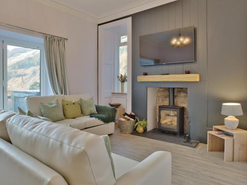 Una sala de estar con un sofá y una chimenea. en Cur Cottage - Uk7809, en Coirantee