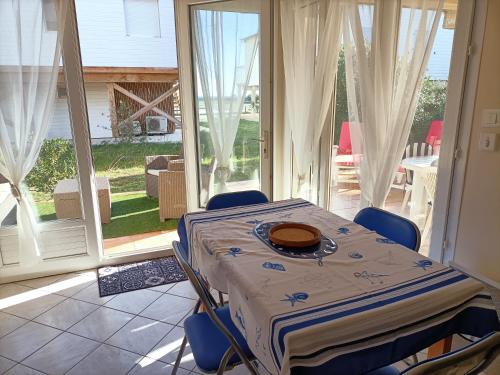 comedor con mesa y sillas y patio en L'esprit marin, en Gruissan