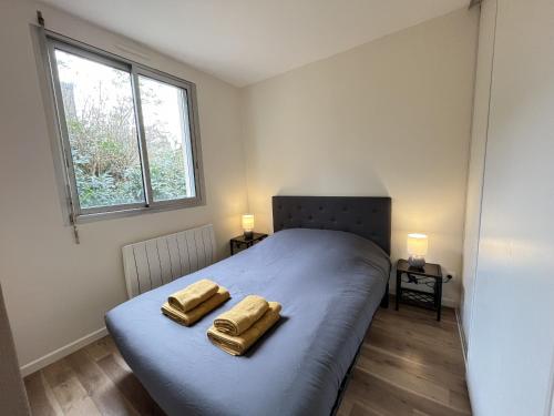 une chambre avec un lit avec deux serviettes dessus dans l'établissement L'Horizon - Parking - Wi-Fi - 2 pers, au Mans