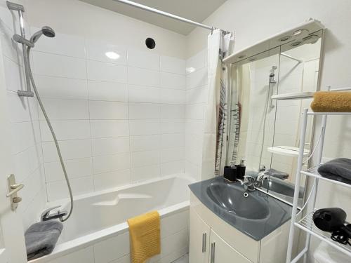 une salle de bain avec un lavabo et une baignoire dans l'établissement L'Horizon - Parking - Wi-Fi - 2 pers, au Mans