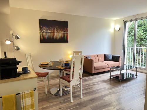 un salon avec une table et un canapé dans l'établissement L'Horizon - Parking - Wi-Fi - 2 pers, au Mans