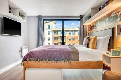 a bedroom with a bed and a large window at Practical Studio For 2 In Leeds with Free Grab&Go Breakfast in Headingley