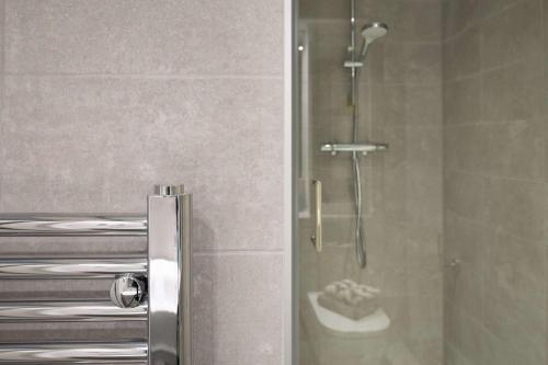 a shower with a glass door in a bathroom at Practical Studio For 2 In Leeds with Free Grab&Go Breakfast in Headingley