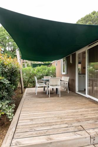 a patio with a table and chairs under a green umbrella at Domaine de Verdagne in Gassin
