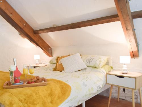 a bedroom with a bed with a tray with champagne glasses at Y Stabl - Uk35032 in Carmarthen