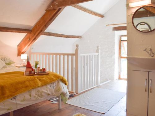 a bedroom with a bed with a yellow blanket at Y Stabl - Uk35032 in Carmarthen