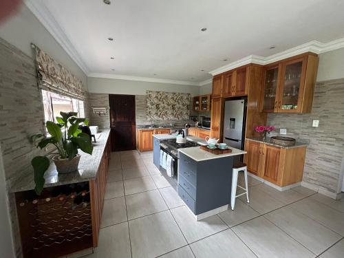 a large kitchen with wooden cabinets and a blue island at Cedara Way Hilton in Hilton