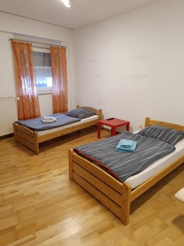 two beds in a room with wooden floors at Ferienwohnung Rolandseck 2 Hauptstraße 42 a in Wahnwegen