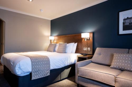 a hotel room with a bed and a chair at Toby Carvery Beckenham by Innkeeper's Collection in Bromley