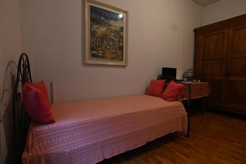 a small bedroom with a bed with red pillows at Villa Francesca B&B in Grumello del Monte