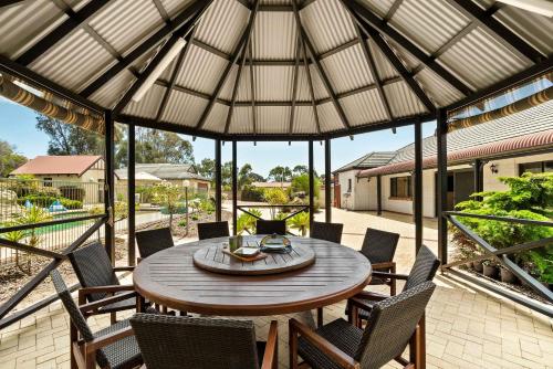 a patio with a wooden table and chairs at Carinya Cove - swimming pool, pet friendly, fireplace in Dunsborough